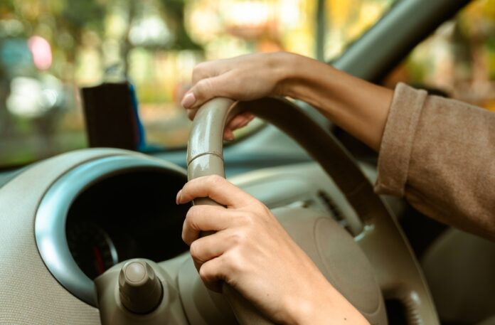 Close up of Hands Holding a Steering Wheel Inside a Car